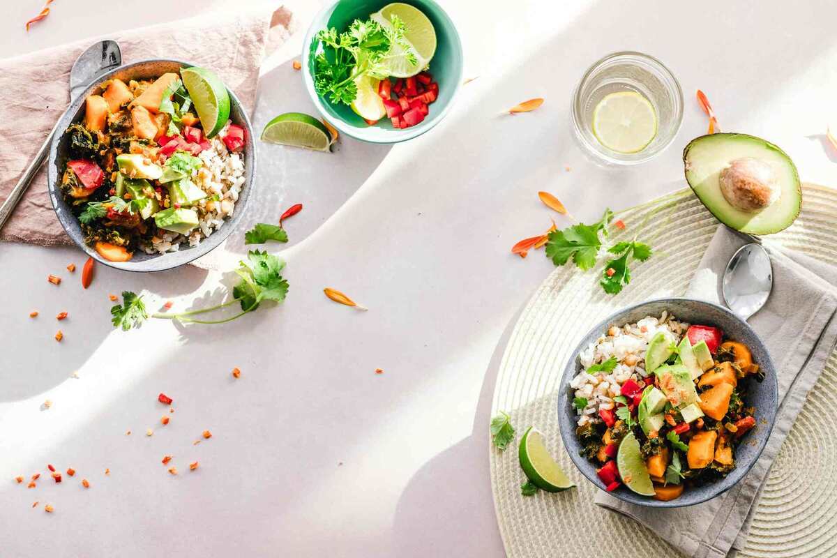 Bowls of brightly colored food on white table cloth